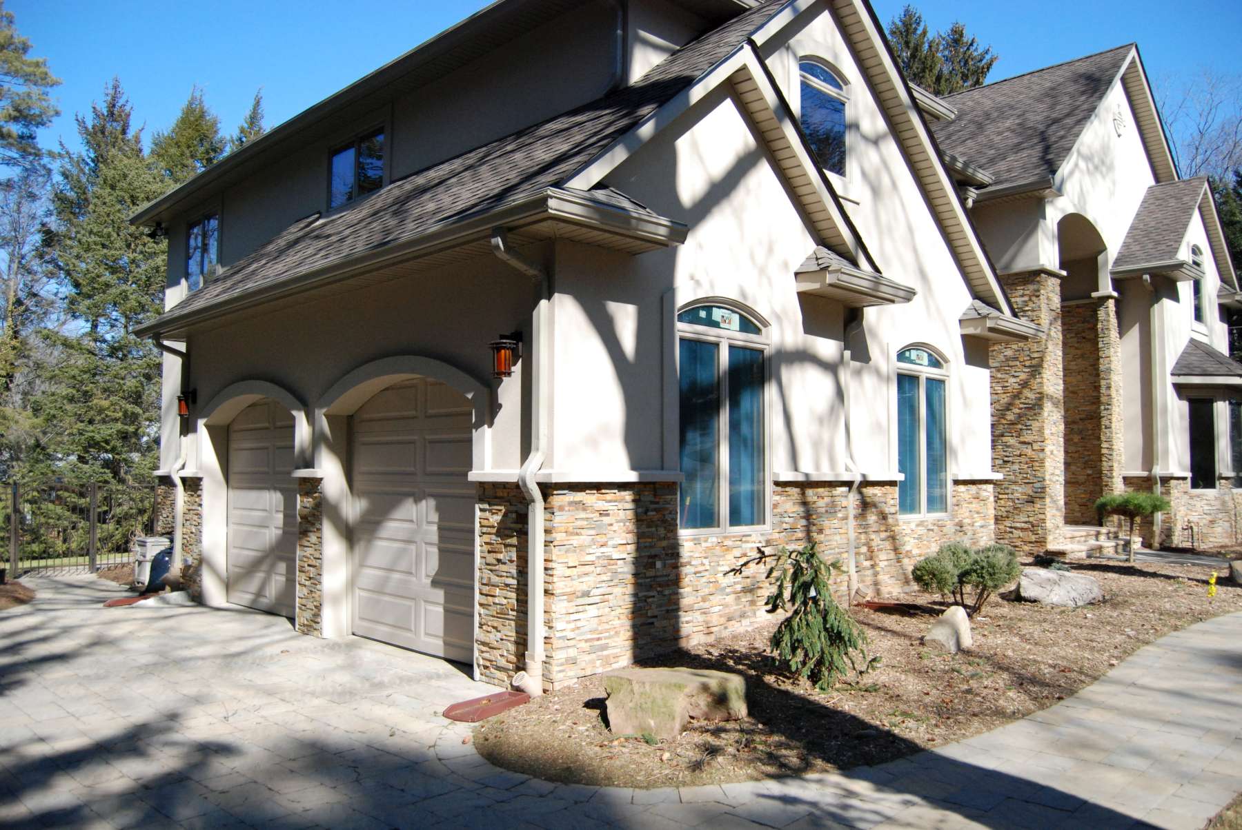 Stone veneer installed over an EIFS system on a residential project with stucco above the stone